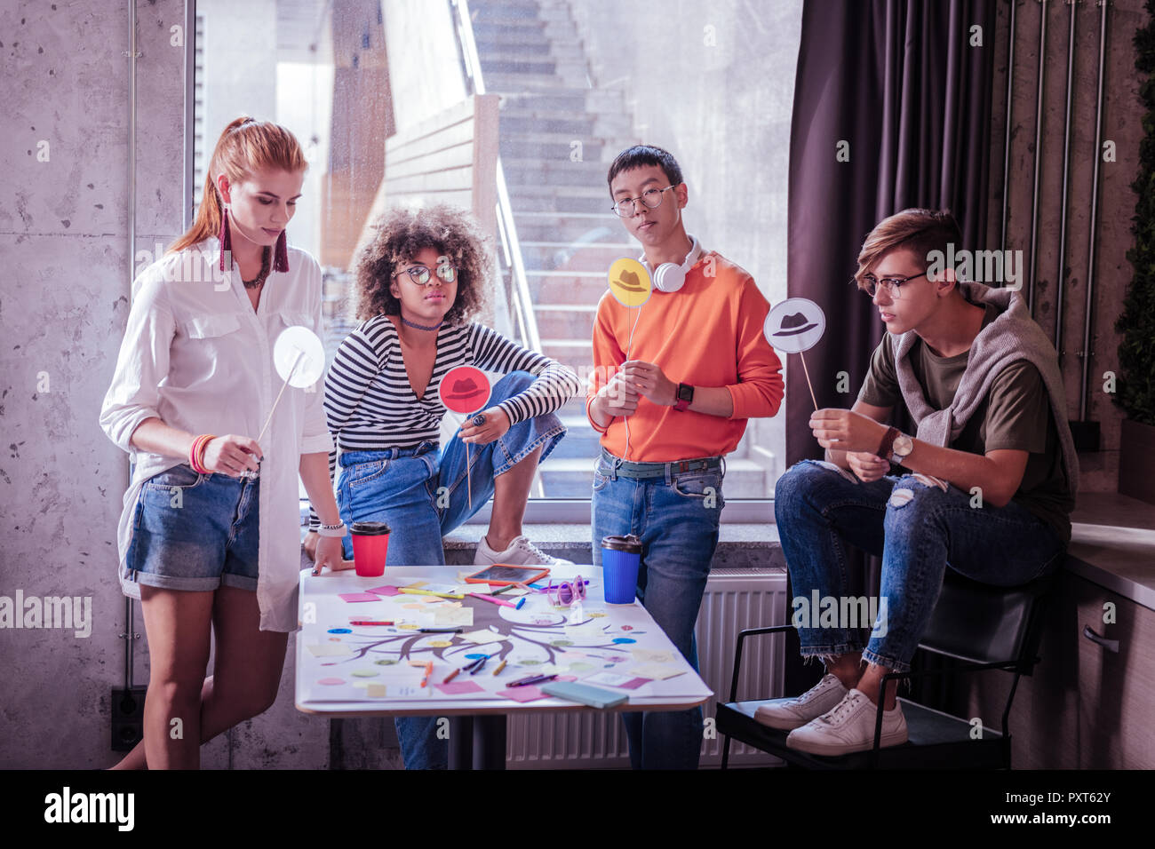 Frustrierte internationalen Schüler halten Bilder auf Stöcke Stockfoto