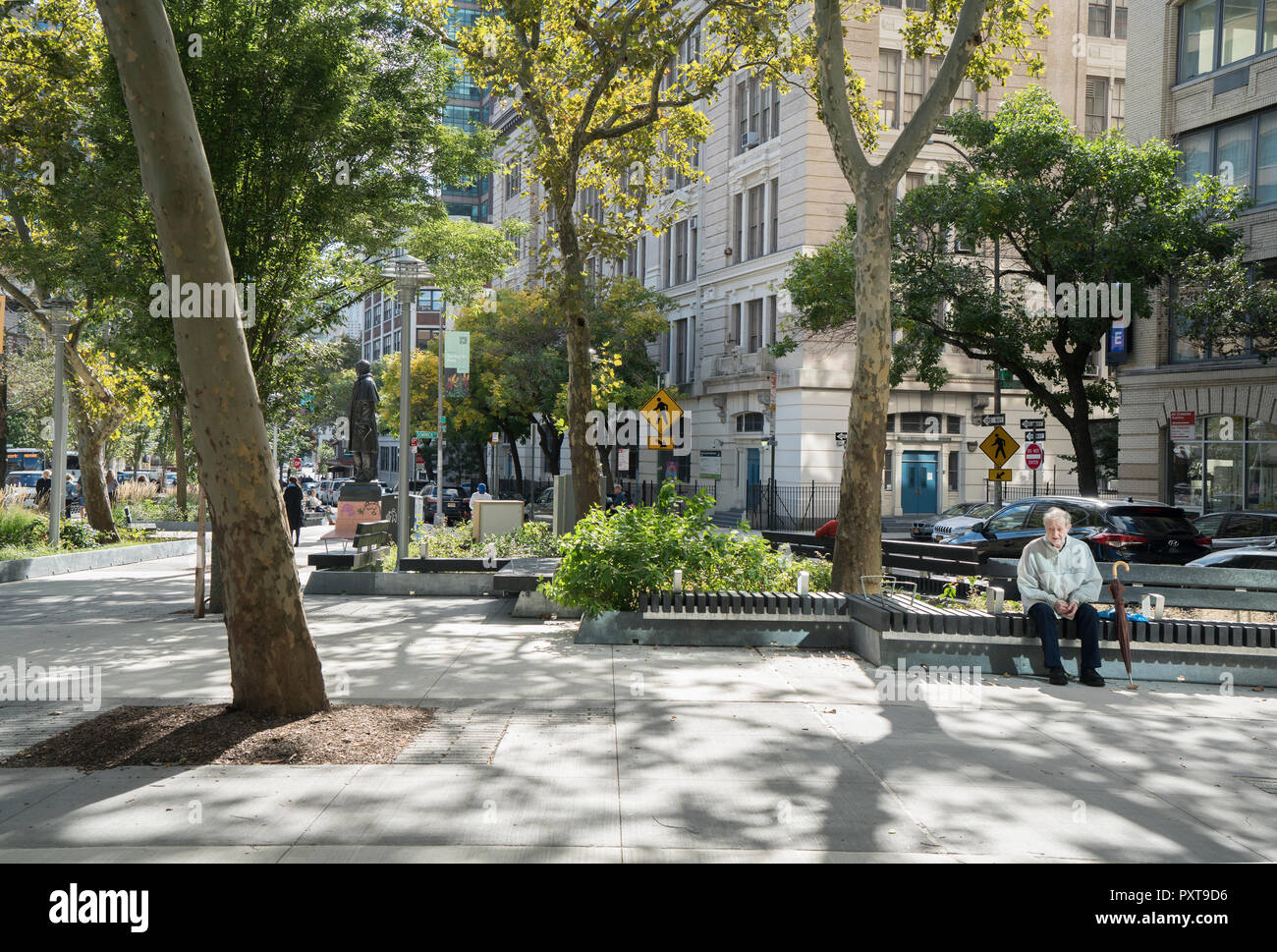 Ein älterer Mann mit einem Regenschirm saß allein in der Spring Street Park an einem sonnigen Tag im Oktober. Der Park liegt südlich von Spring Street in Manhattan Soho. Stockfoto