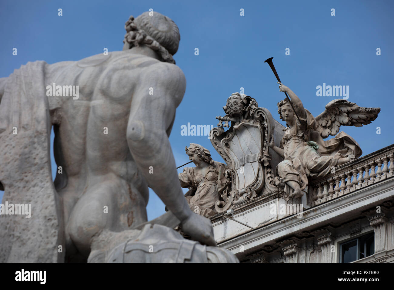 Statue von Castor & Pollux auf dem Brunnen von der Quirinal Palast und das Päpstliche Wappen auf der Balustrade aus einem nahe gelegenen Gebäude mit Engel & Trompete Stockfoto