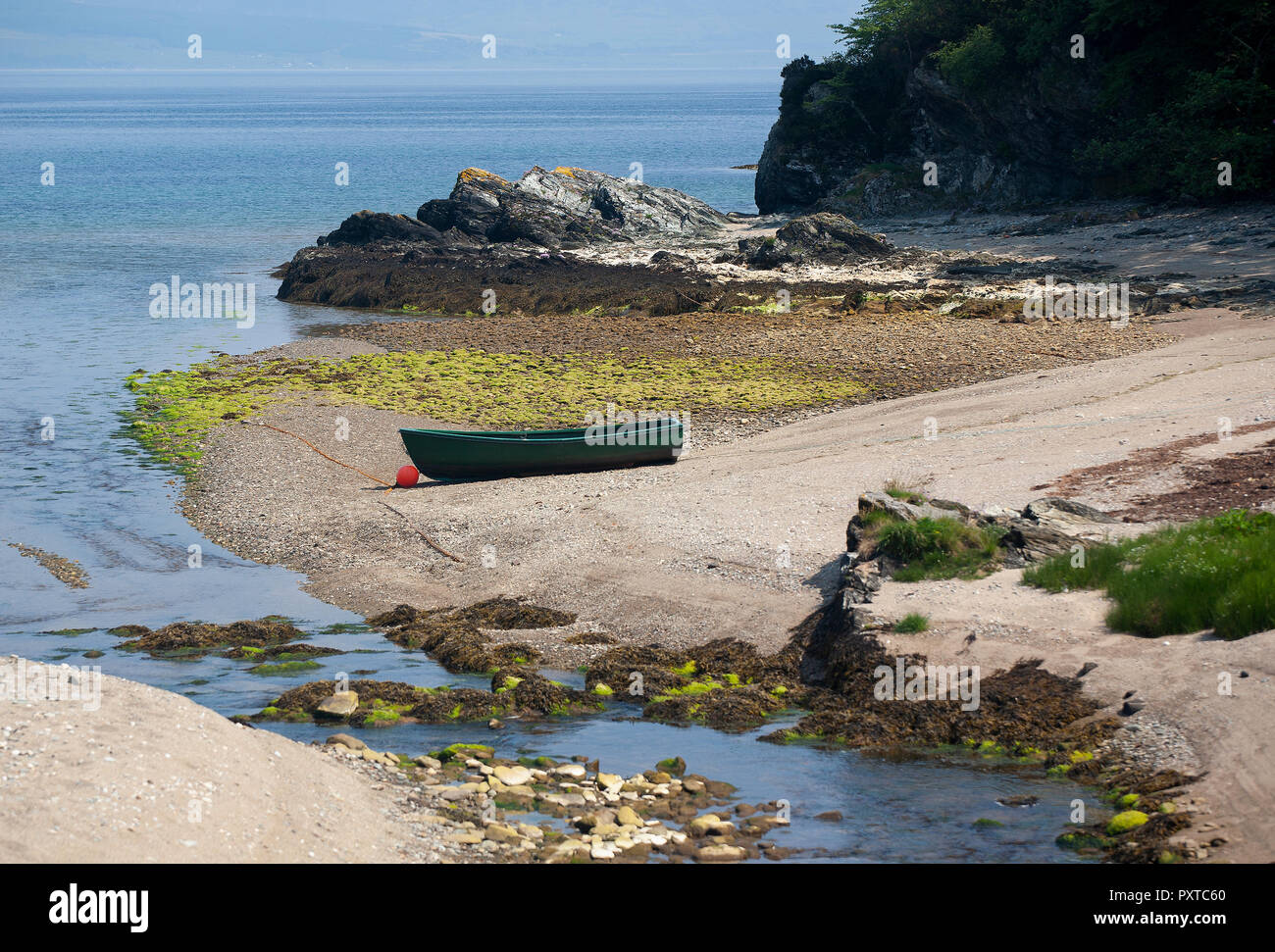 Ein kleines Ruderboot zog auf einen Kiesstrand von einem kleinen Bach auf einem wilden und abgelegenen Küste. Stockfoto