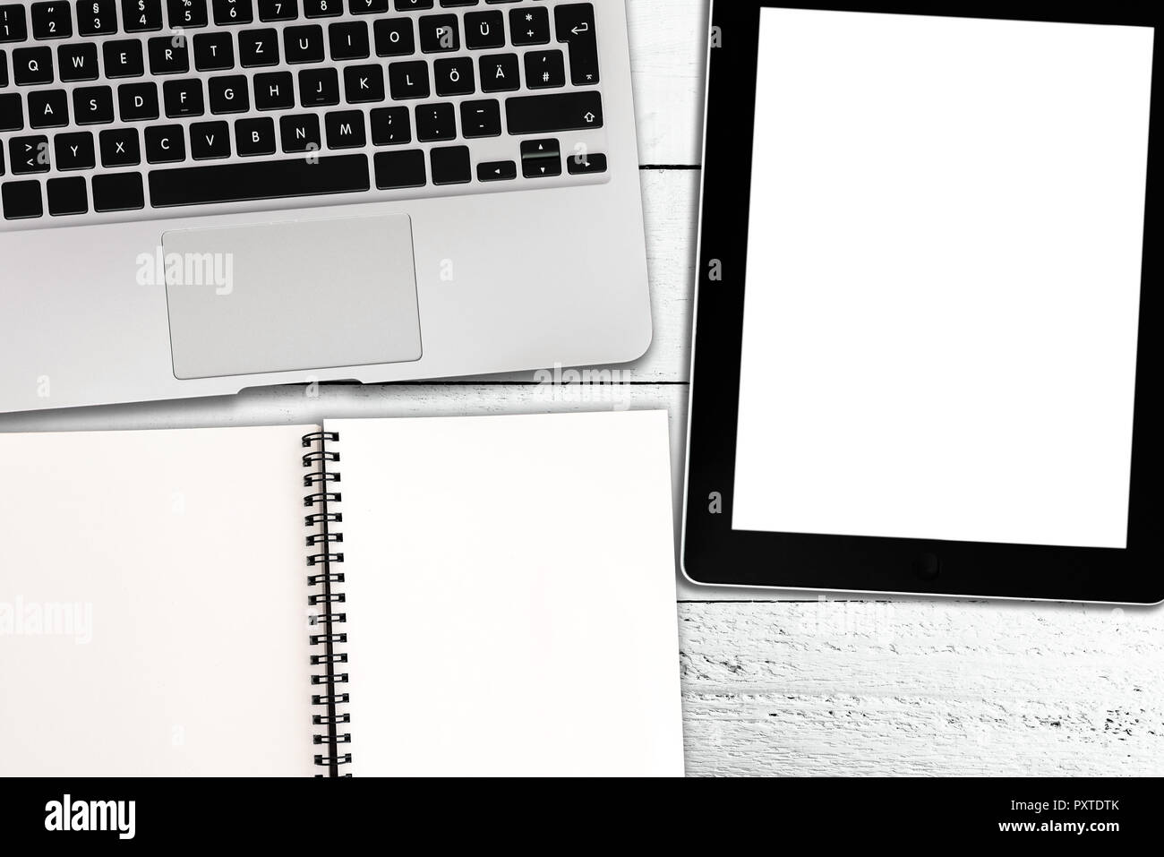 Laptop, Tablet-PC und Spirale Notizblock auf rustikalen weiße Holztisch Stockfoto