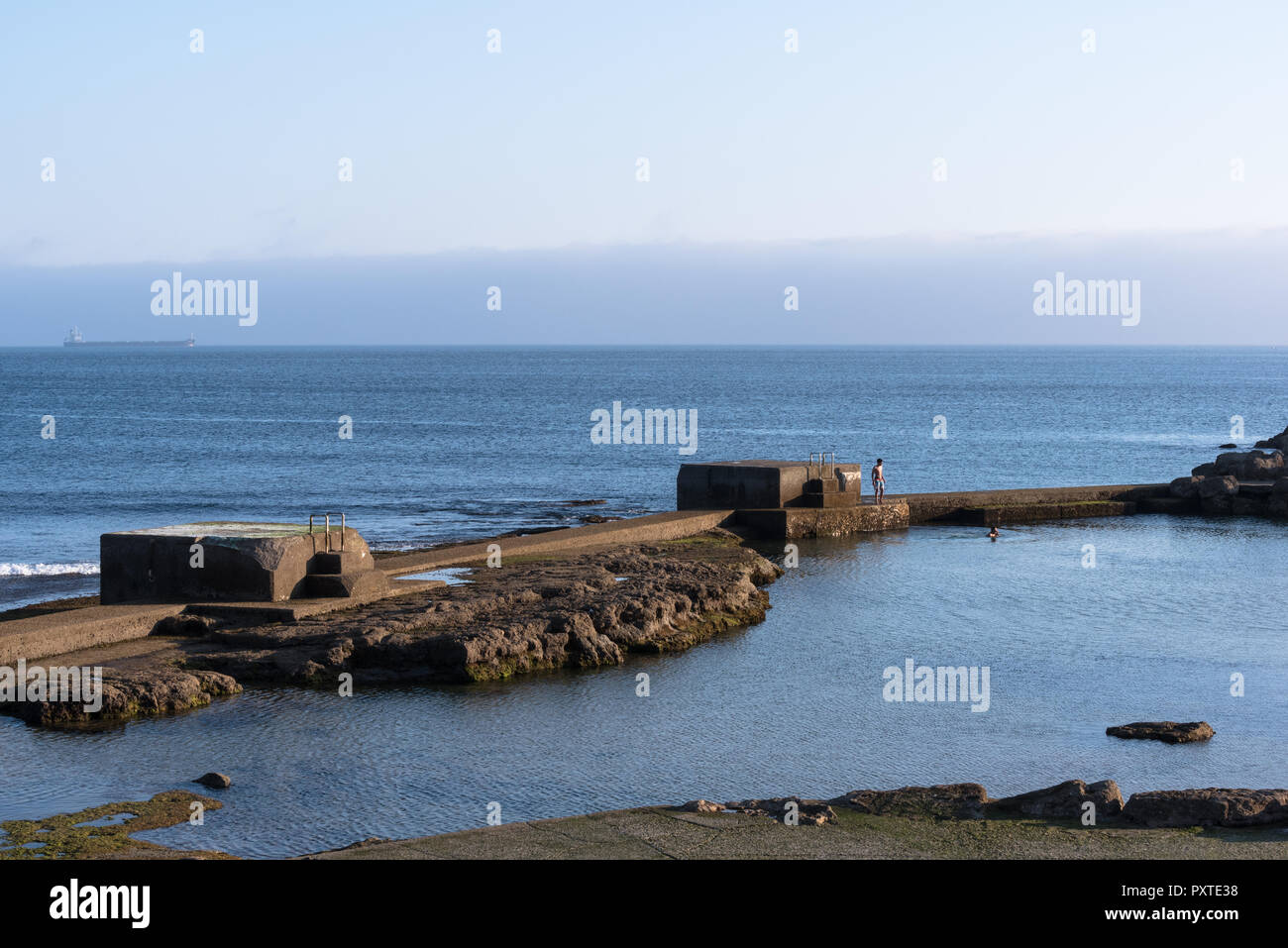 Estoril, Portugal - Juli 9, 2018: Zwei junge Männer baden in Meerwasser Pool neben dem Atlantik in der Nähe der Promenade in Estoril Portugal Stockfoto