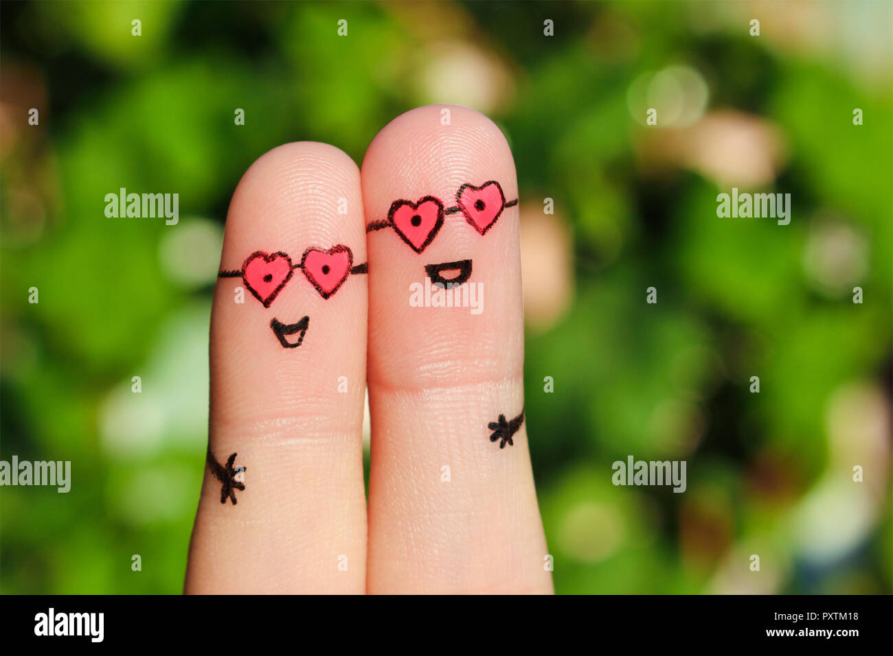 Finger Kunst der ein glückliches Paar. Ein Mann und eine Frau umarmen in rosa  Brille in Form der Herzen. Das Konzept der Liebe auf den ersten Blick  Stockfotografie - Alamy