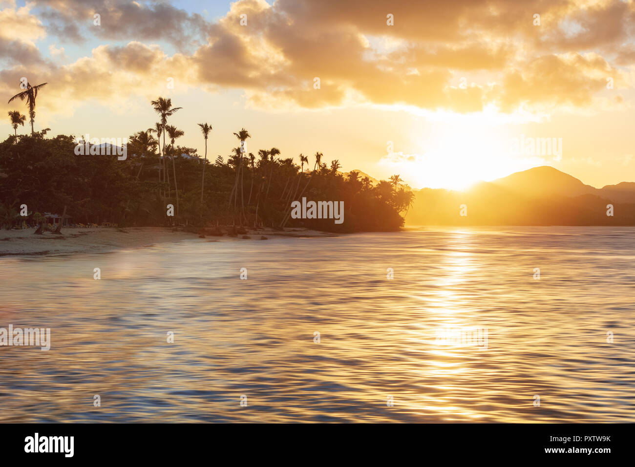 Sunset Beach mit hohen Palmen und glühenden Himmel Stockfoto