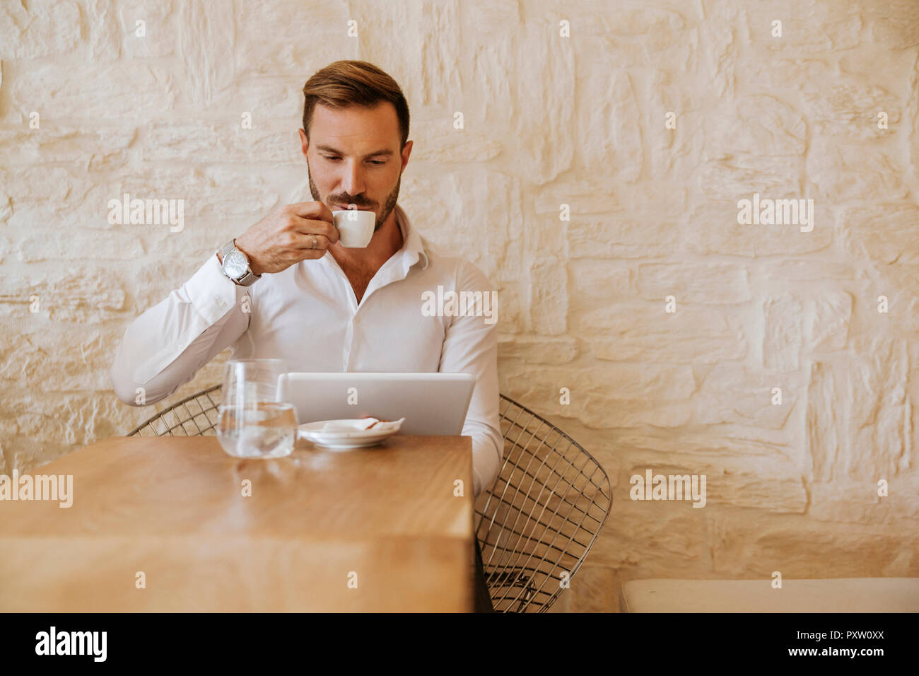 Mann mit Tablet trinken Espresso in einem Café Stockfoto