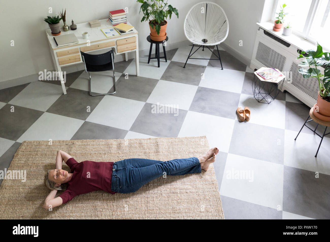Entspannt reife Frau auf dem Boden liegend zu Hause Stockfoto