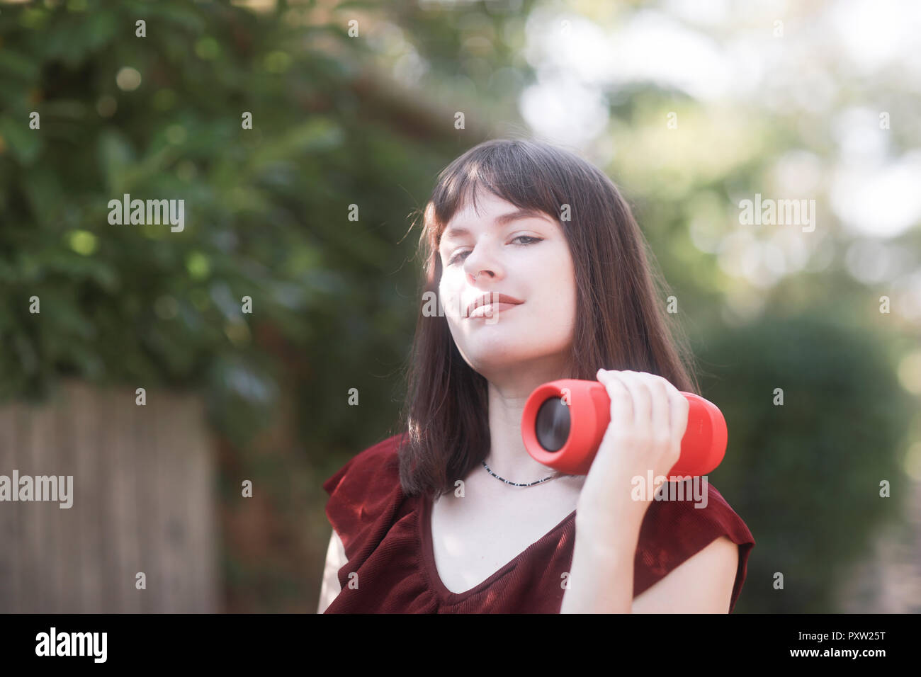 Junge Frau mit Bluetooth Lautsprecher, Musik hören Stockfoto