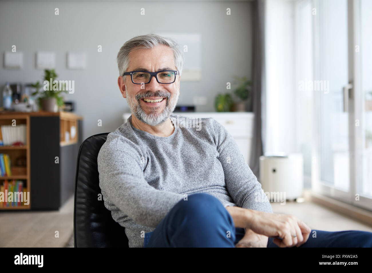 Portrait von Inhalten reifer Mann in seinem Wohnzimmer Stockfoto
