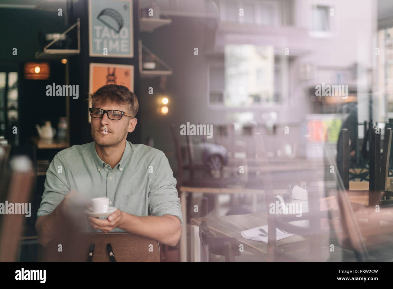 Junge Unternehmer in seinem Café sitzen, Kaffee trinken Stockfoto