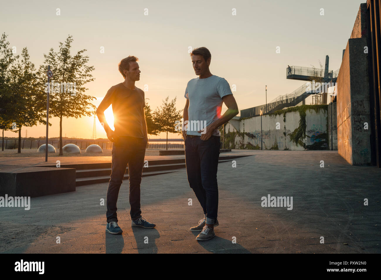Zwei Freunde treffen bei Sonnenuntergang, am Abend reden Stockfoto