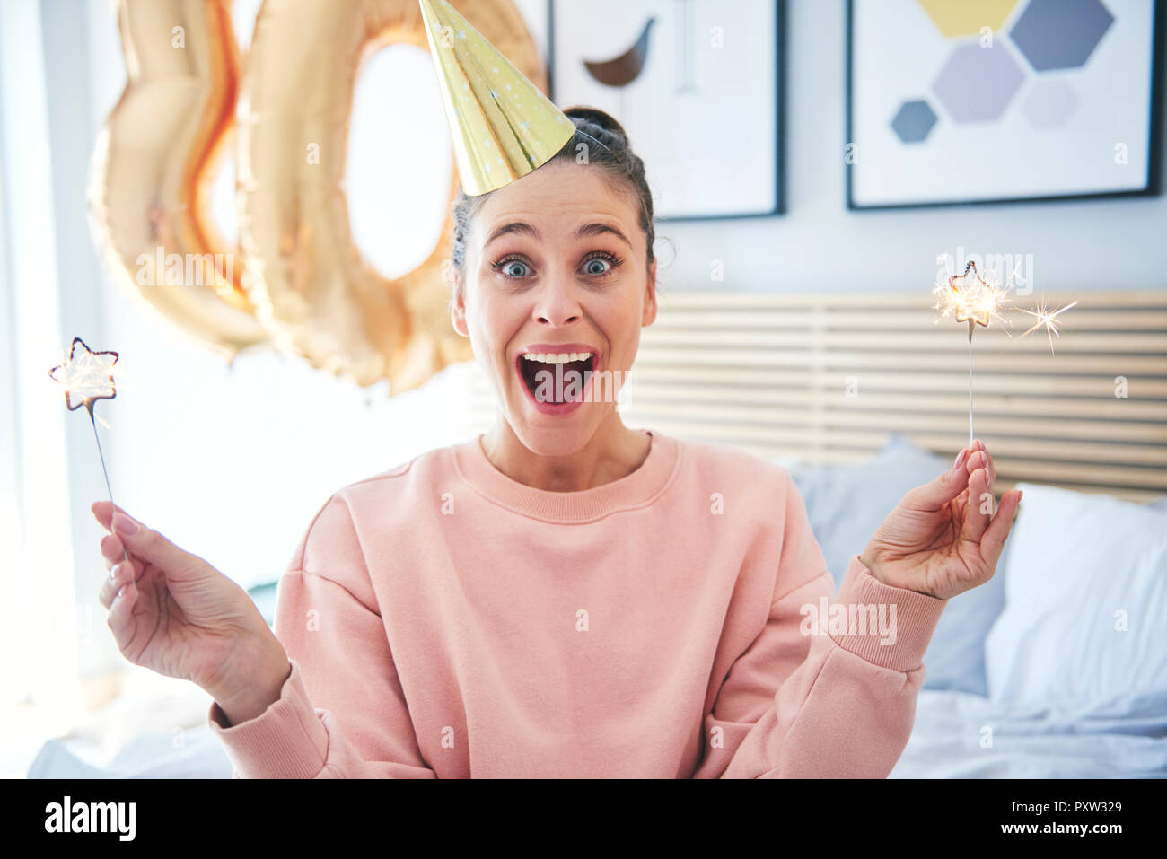 Fröhliche Frau bei ihren Geburtstag mit Wunderkerzen Stockfoto