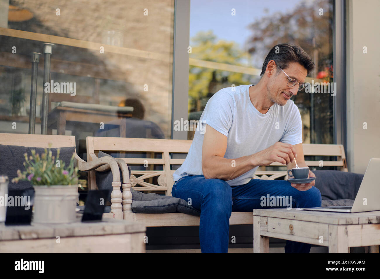Reifen Geschäftsmann im Café sitzen, Kaffee trinken, mit Laptop Stockfoto