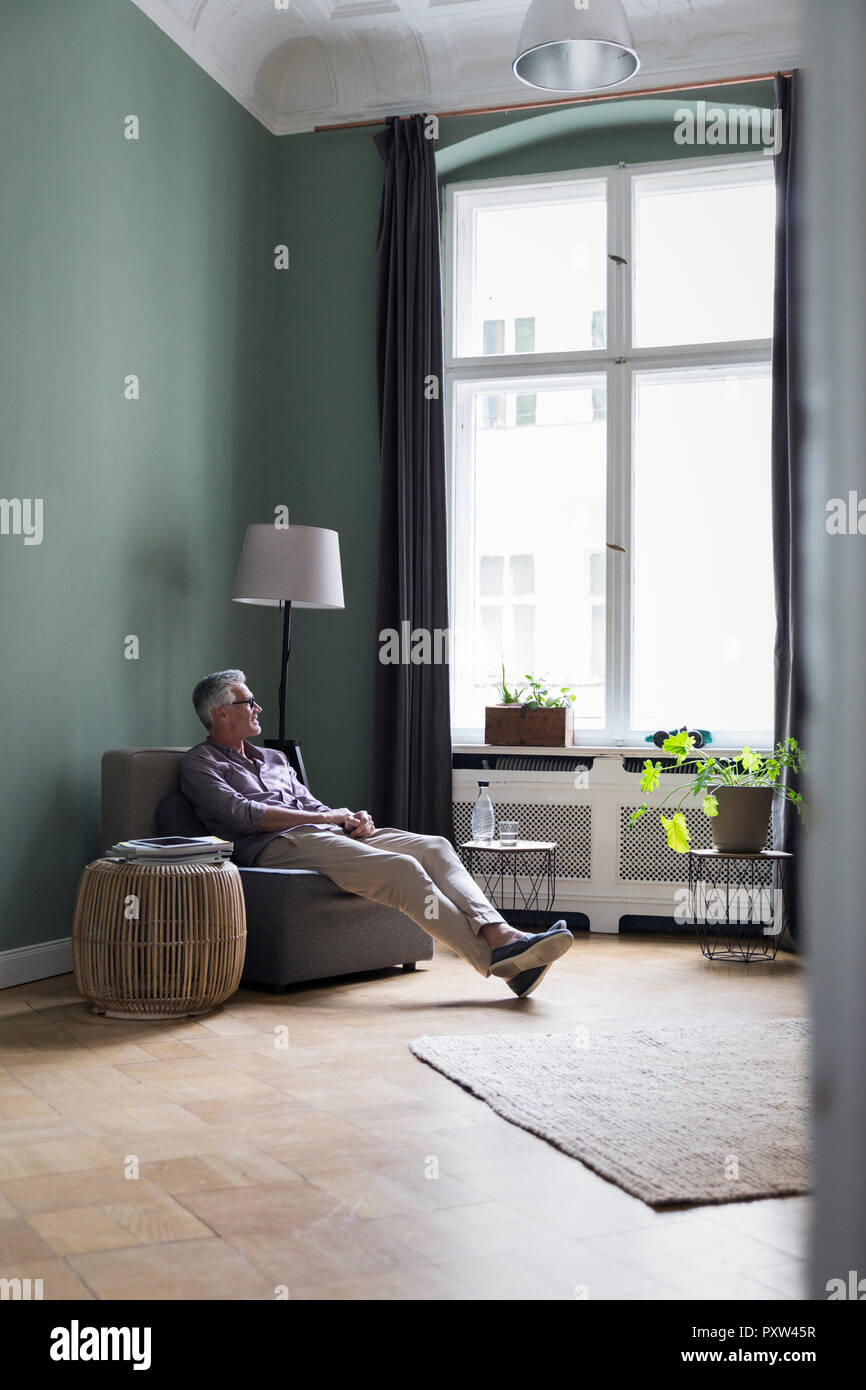 Entspannt reifer Mann zu Hause sitzen Stockfoto