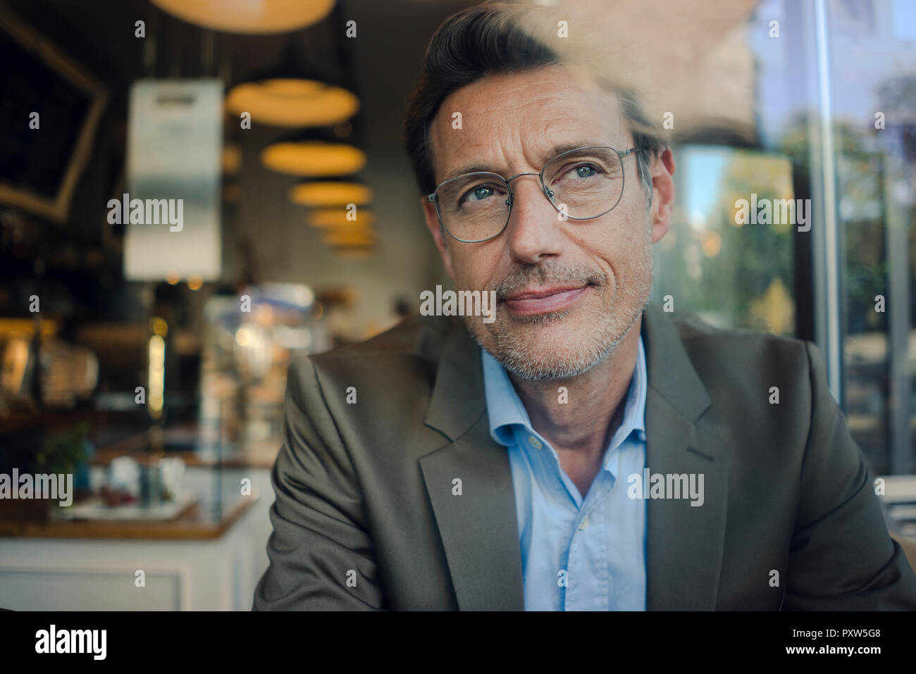 Reifen Geschäftsmann im Café sitzen, lächeln Stockfoto