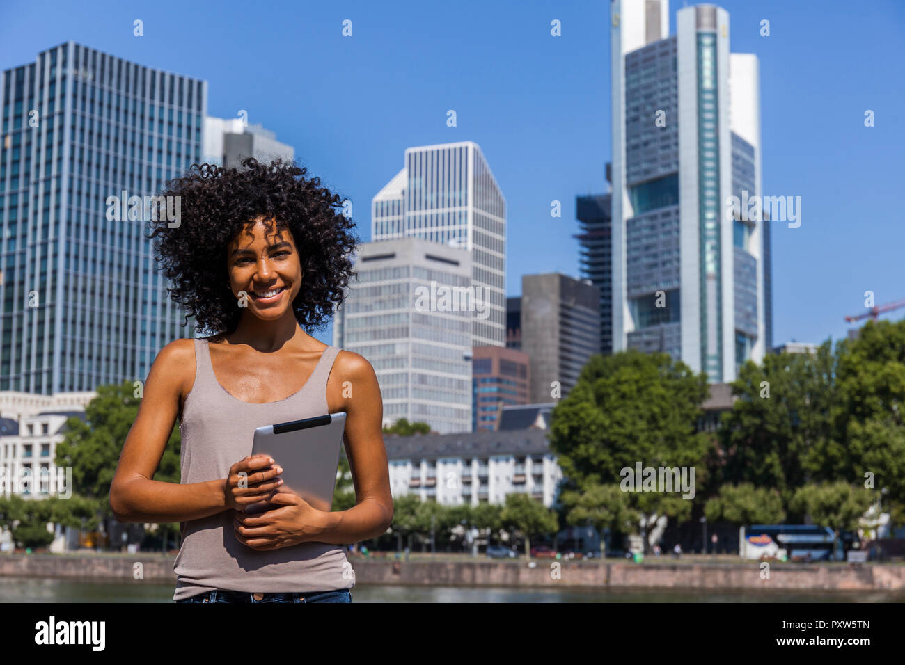 Deutschland, Frankfurt, Portrait von lächelnden jungen Frau mit digitalen Tablet in der Stadt Stockfoto