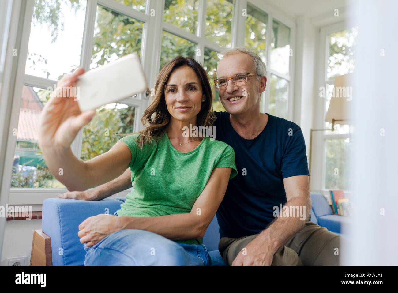 Lächelnd reifes Paar ein selfie zu Hause Stockfoto