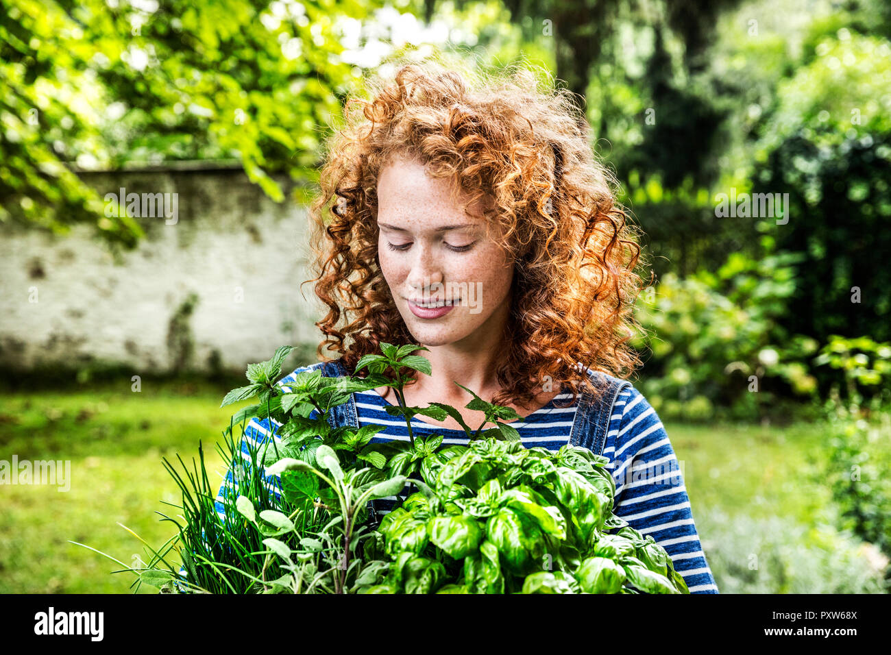 Porträt der jungen Frau mit frischen Kräutern im Garten Stockfoto