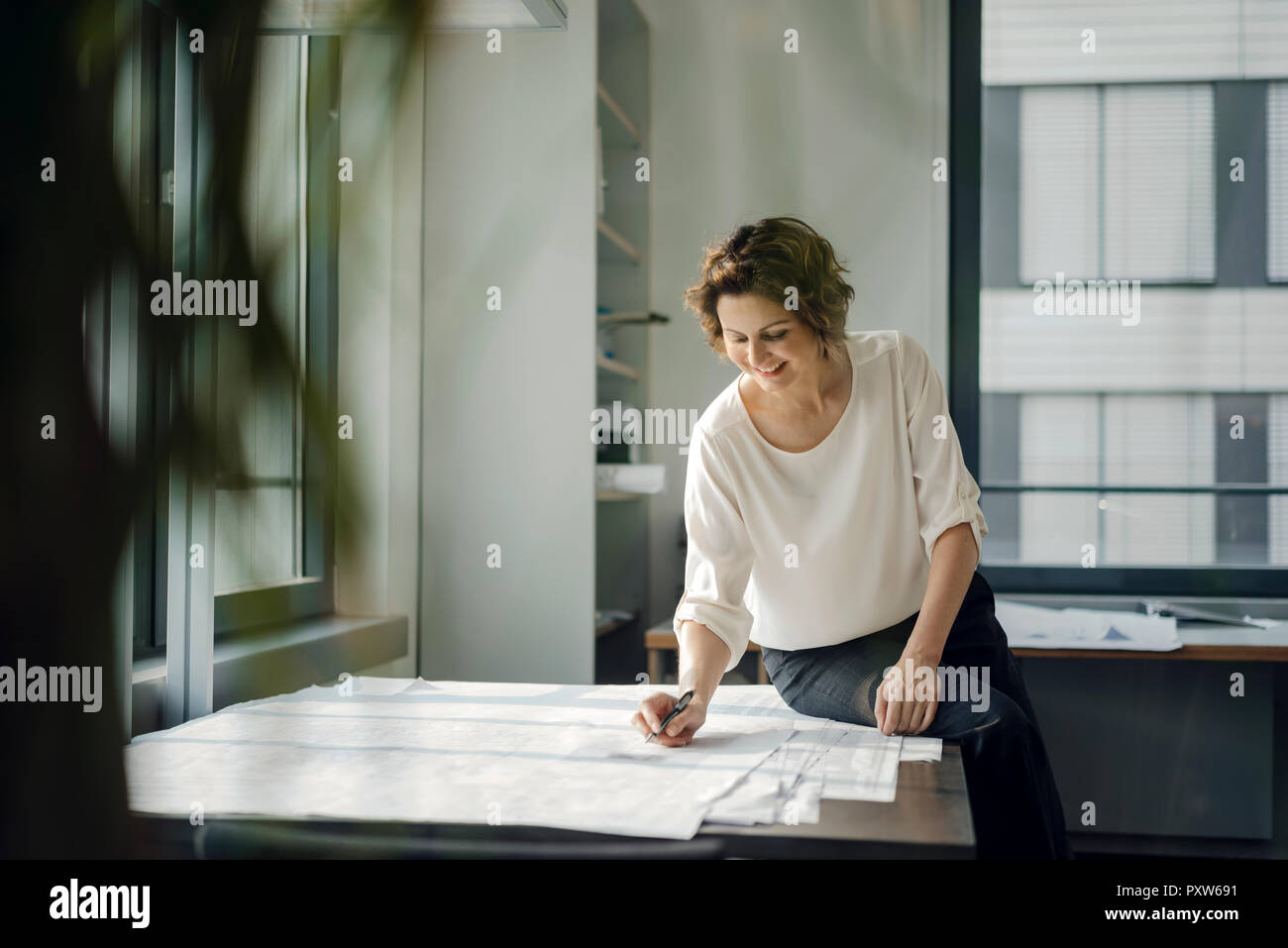 Geschäftsfrau im Büro, arbeiten auf Blueprints Stockfoto