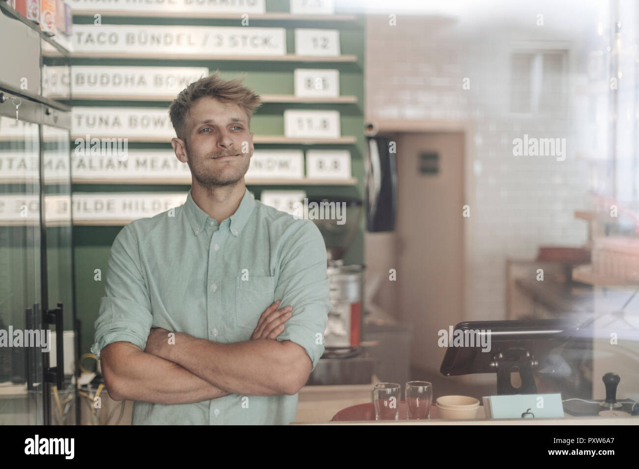Junger Mann bei der Arbeit in seinem Start-up-cafe, Porträt Stockfoto