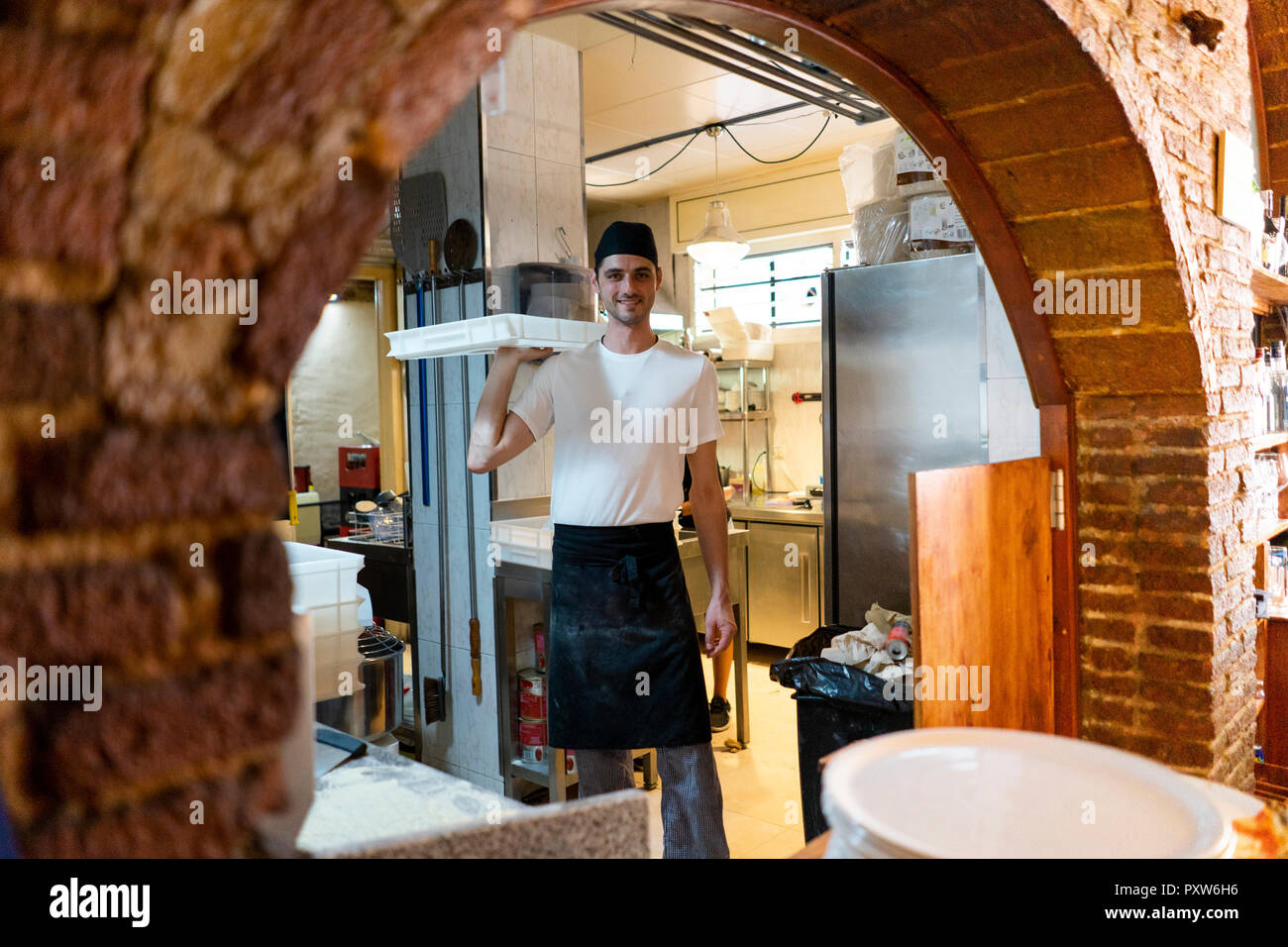 Portrait von lächelnden Pizza Bäcker Holding eine Box in der Küche Stockfoto