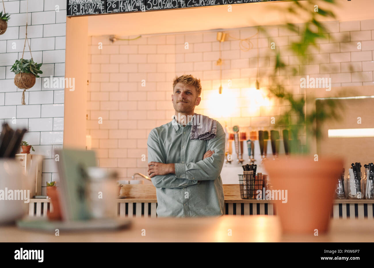 Junger Mann bei der Arbeit in seinem Start-up-cafe, Porträt Stockfoto