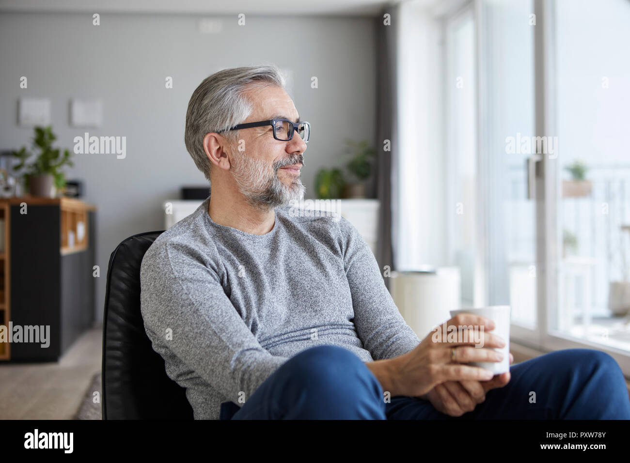 Inhalt reifer Mann Entspannung bei einer Tasse Kaffee zu Hause Stockfoto