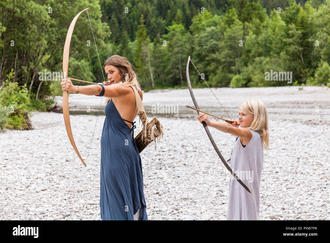 Mutter und Tochter, die mit Pfeil und Bogen in der Natur Stockfoto