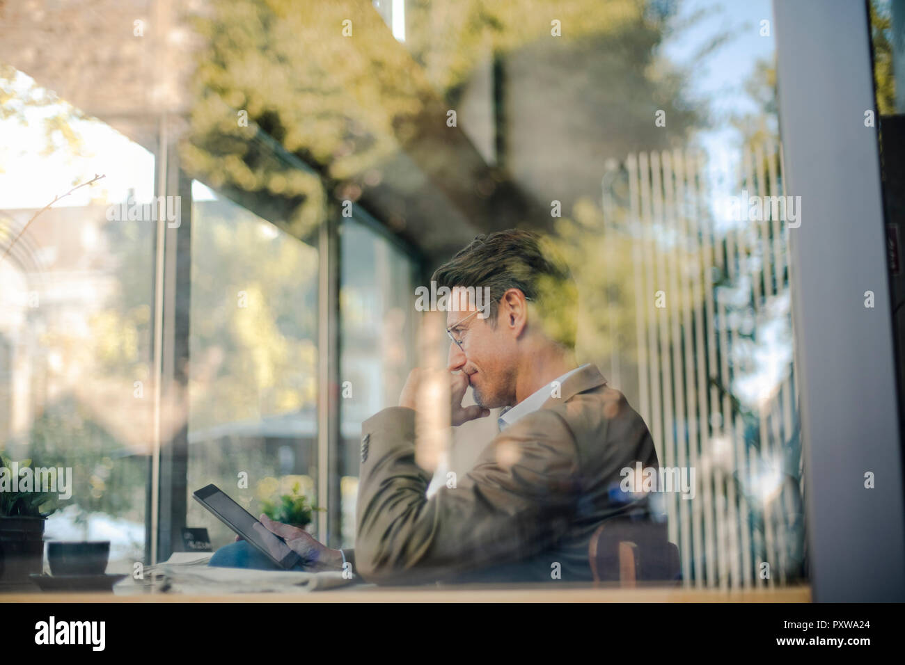 Reifen Geschäftsmann im Café sitzen, mit digitalen Tablet Stockfoto