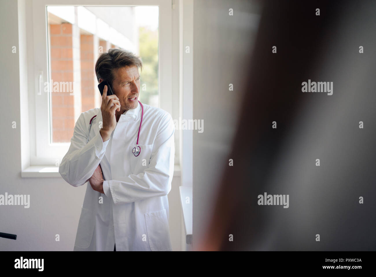 Arzt im Krankenhaus, sie ihr Smartphone Stockfoto