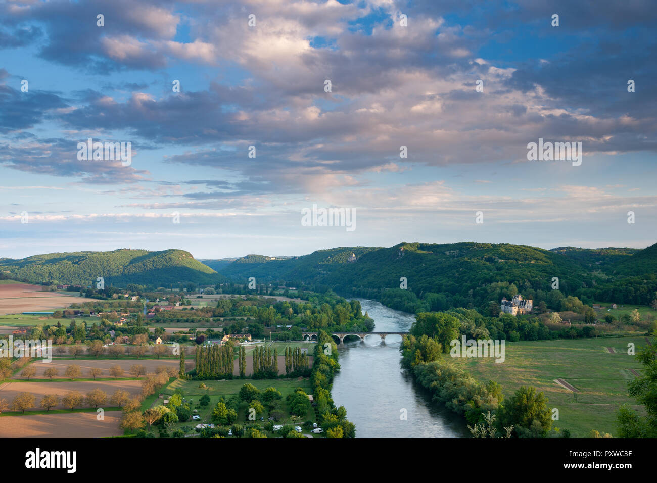 Die Dordogne bei Sonnenuntergang mit gewölbten Steinbrücke und Chateau Fayrac und Castlenaud in der Ferne Stockfoto