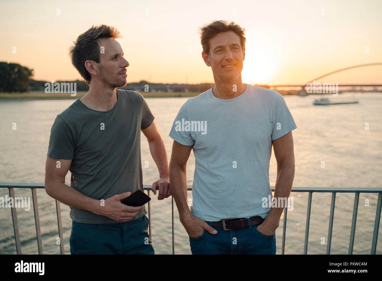 Zwei Freunde treffen bei Sonnenuntergang, am Abend reden Stockfoto