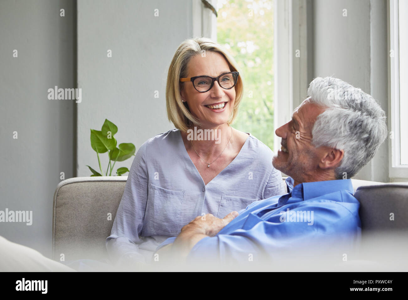 Glückliches junges Paar auf der Couch zu Hause Stockfoto