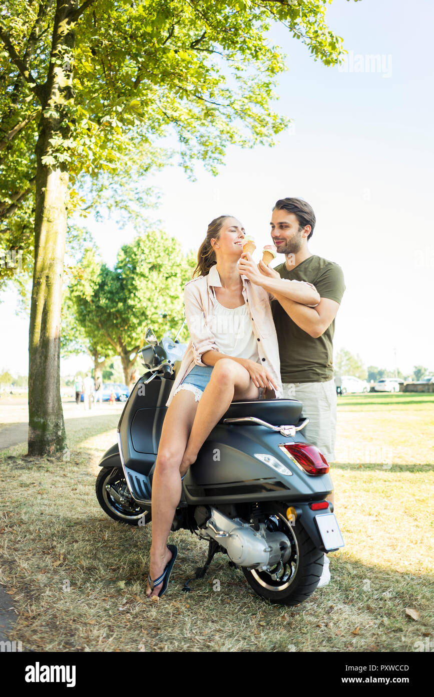 Glückliches Paar mit motor scooter im Sommer Eis essen Stockfoto