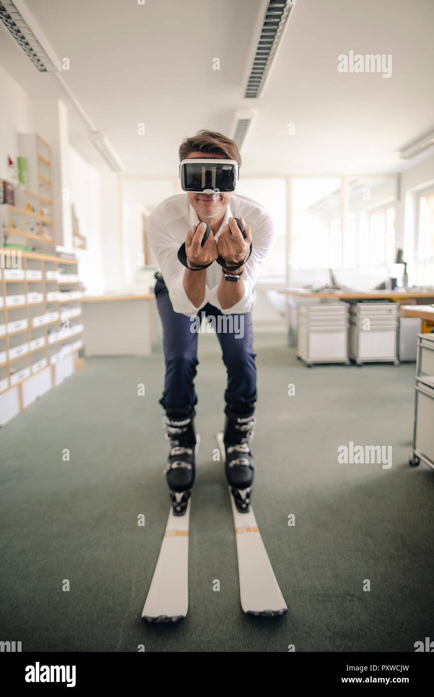 Geschäftsmann Skifahren im Büro, mit VR-Brille Stockfoto