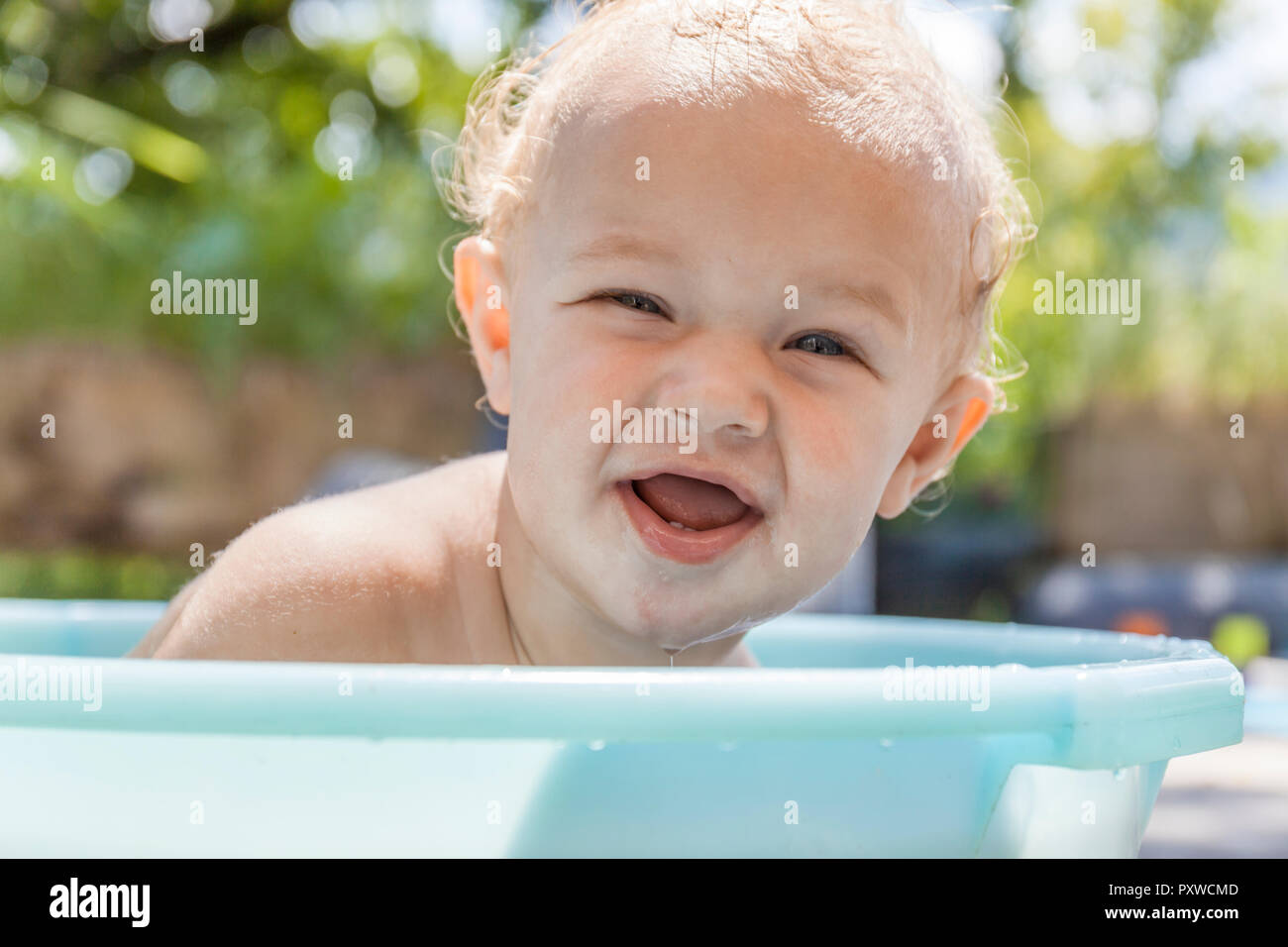 Junge in Baby Badewanne sitzen Stockfoto