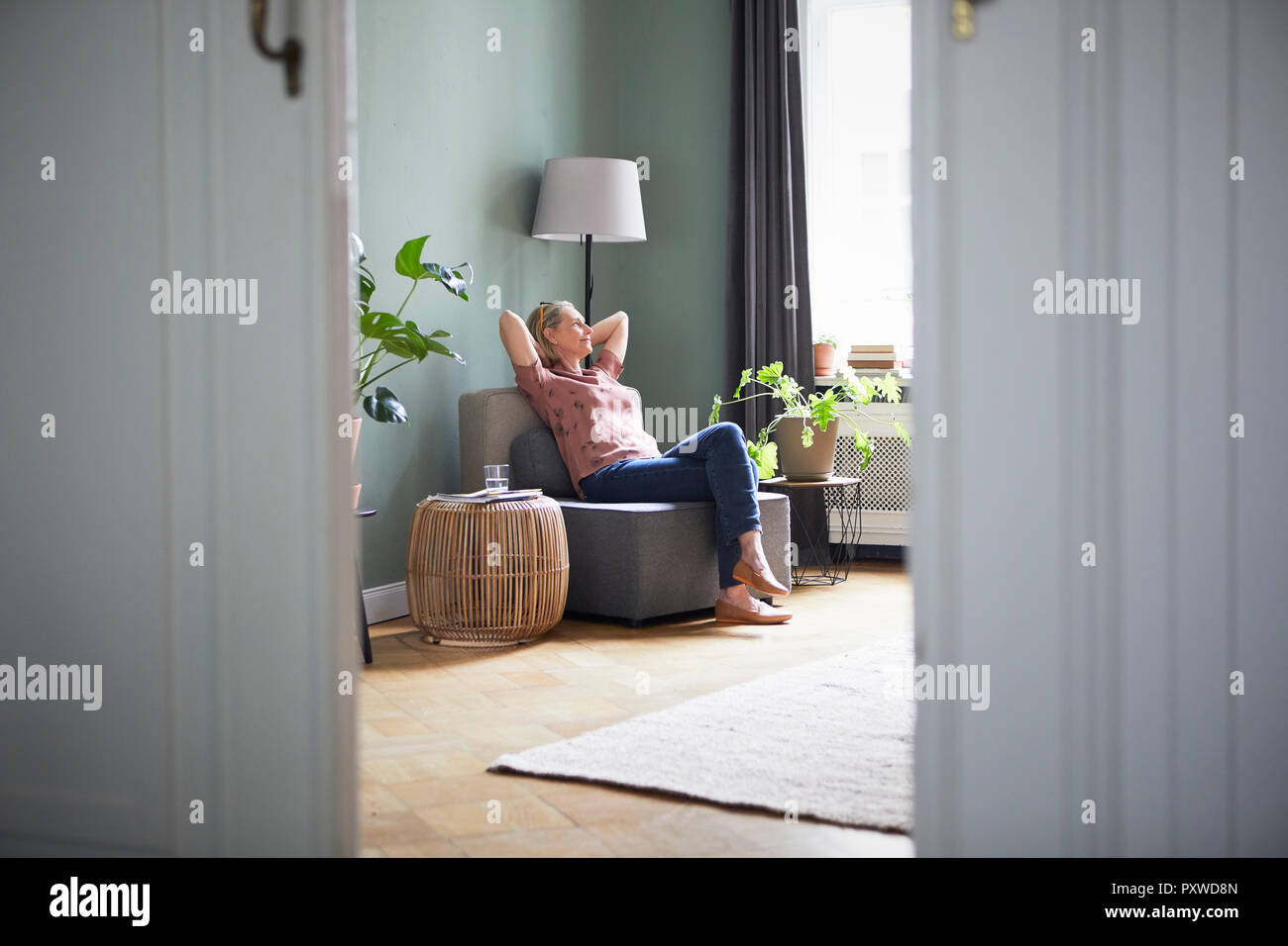 Entspannt reife Frau zu Hause sitzen Stockfoto