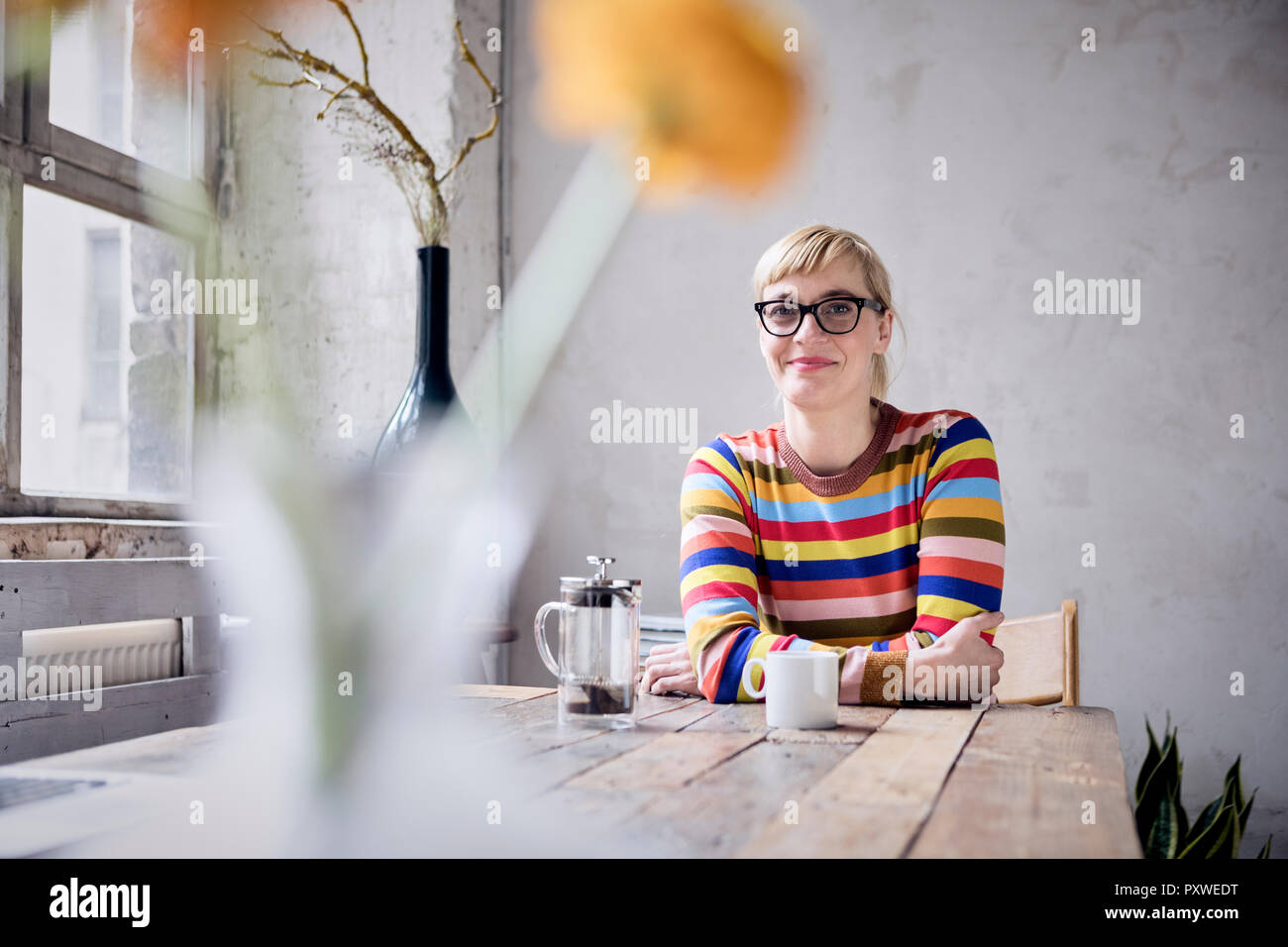 Porträt der lächelnde Frau mit Tasse Kaffee in einer Loft Stockfoto