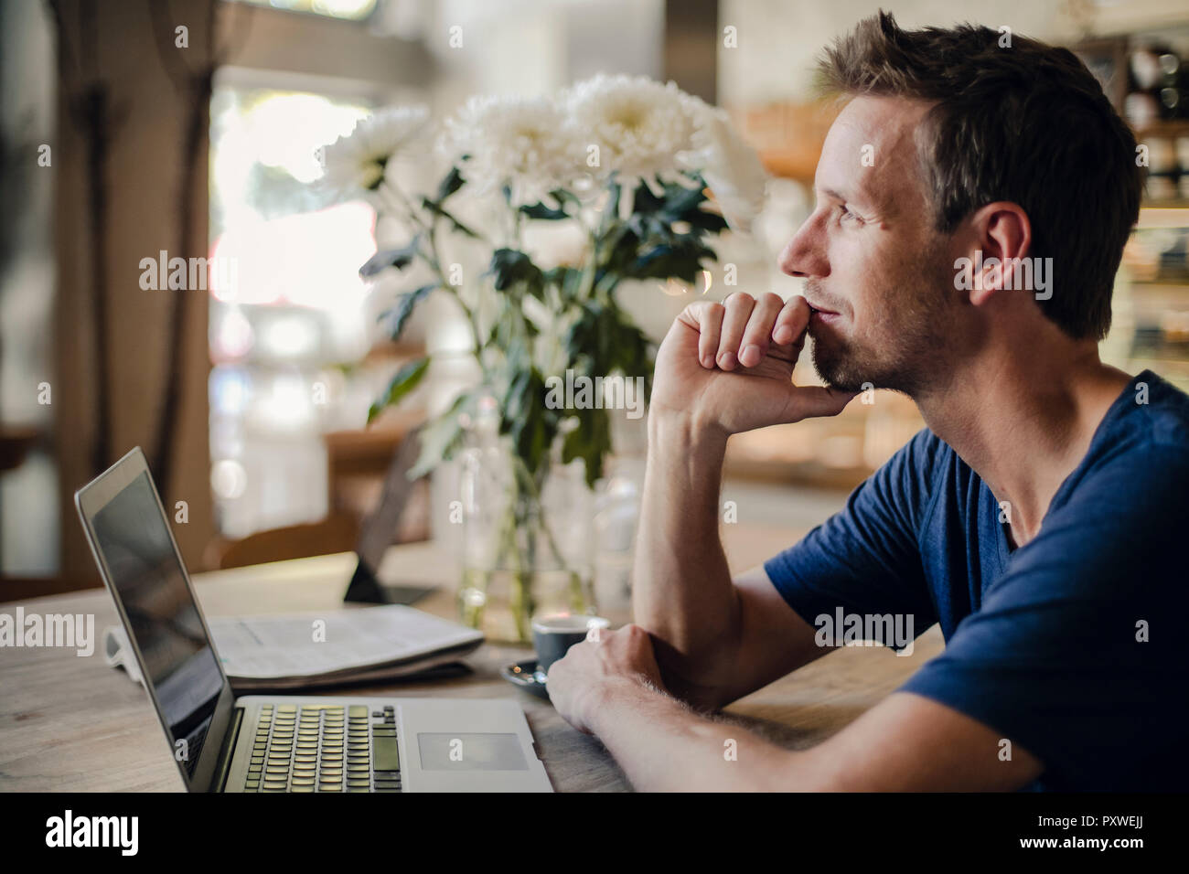 Mitte der erwachsenen Mann im Café sitzen, mit Laptop Stockfoto