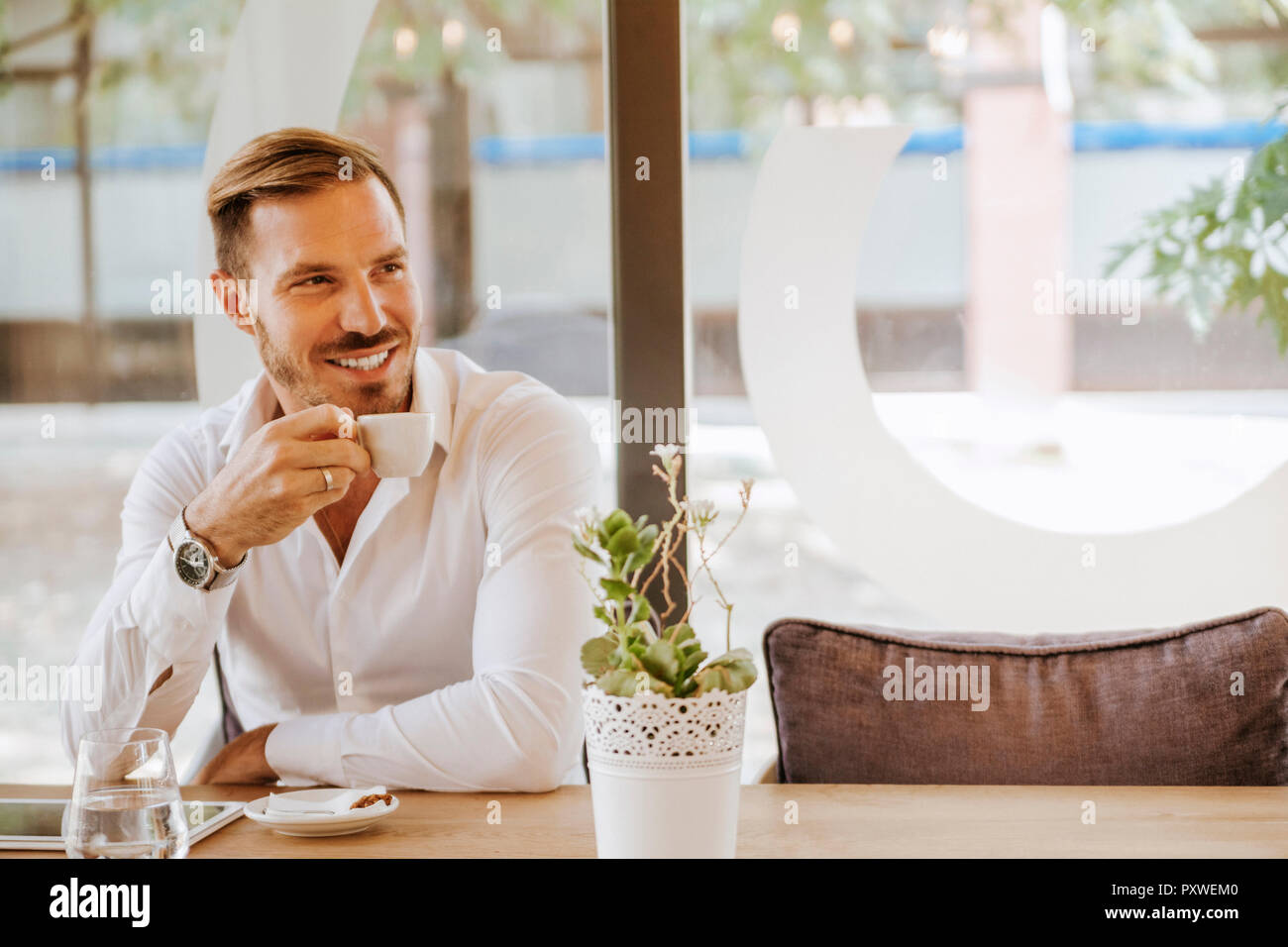 Lächelnder Mann mit Tablet trinken Espresso in einem Café Stockfoto