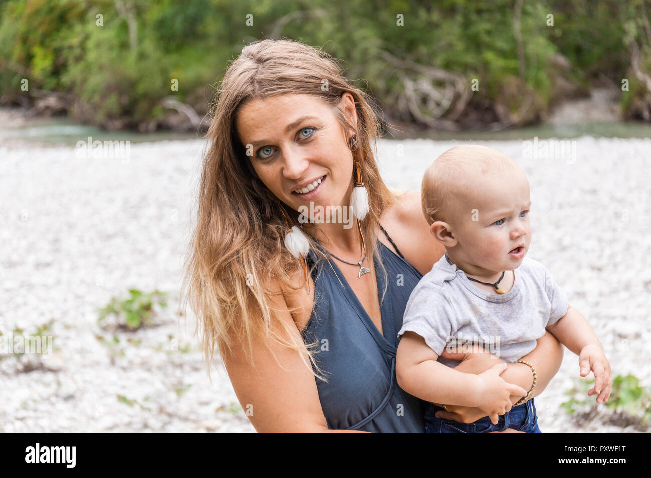 Portrait von lächelnden Mutter Holding baby boy draußen in der Natur Stockfoto