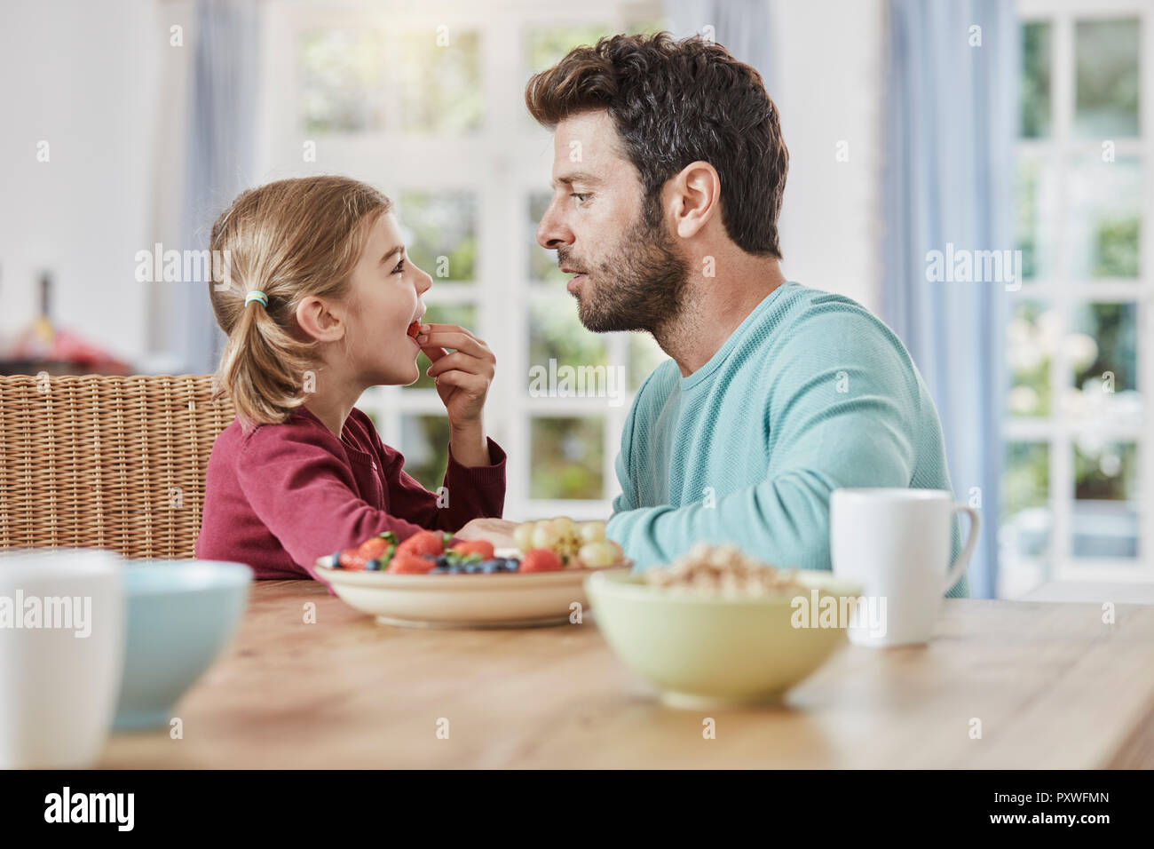 Vater und Tochter das Essen von Früchten zu Hause Stockfoto