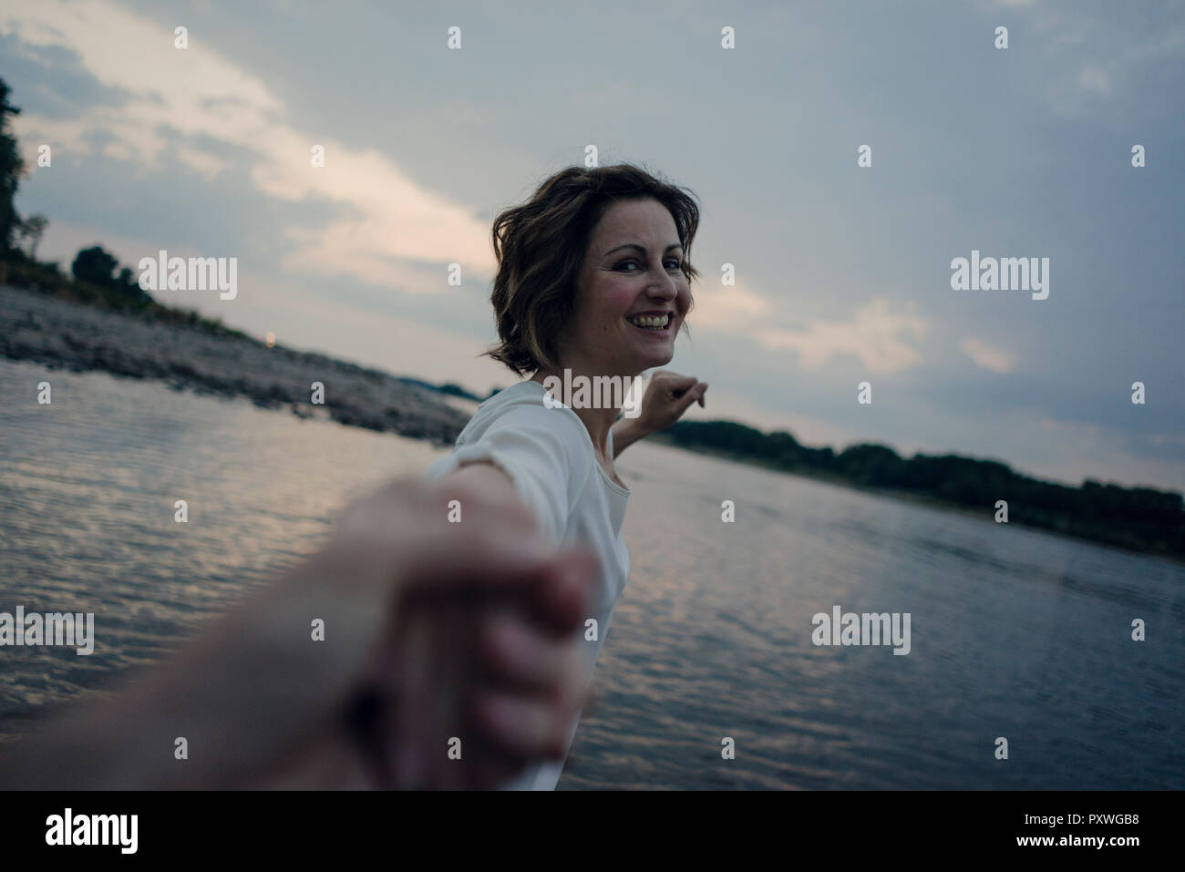 Lachende Frau mit Händen am Fluss Stockfoto