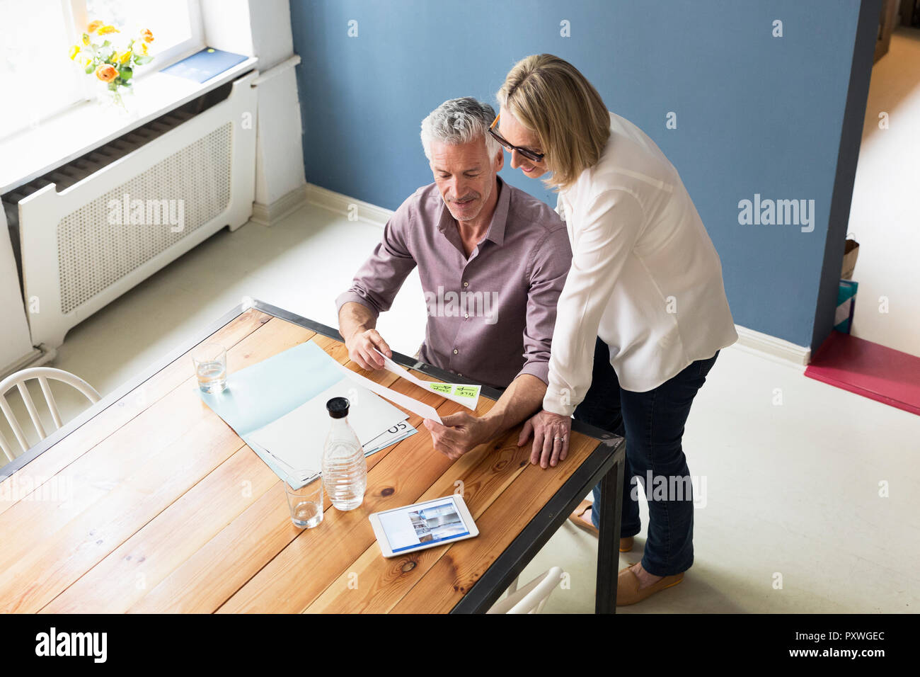 Älteres Ehepaar mit Dokumenten und Tablette zu Hause Stockfoto