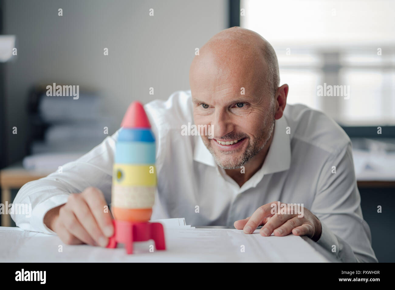 Geschäftsmann spielen mit Spielzeug, Rakete im Büro Stockfoto