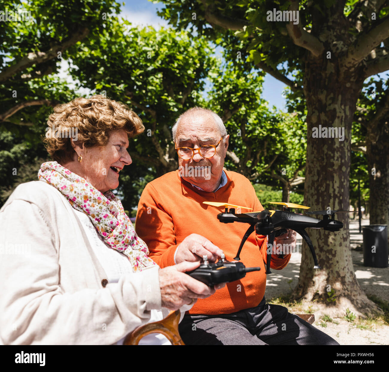 Senior Paar spielen mit einer Drohne in Park Stockfoto