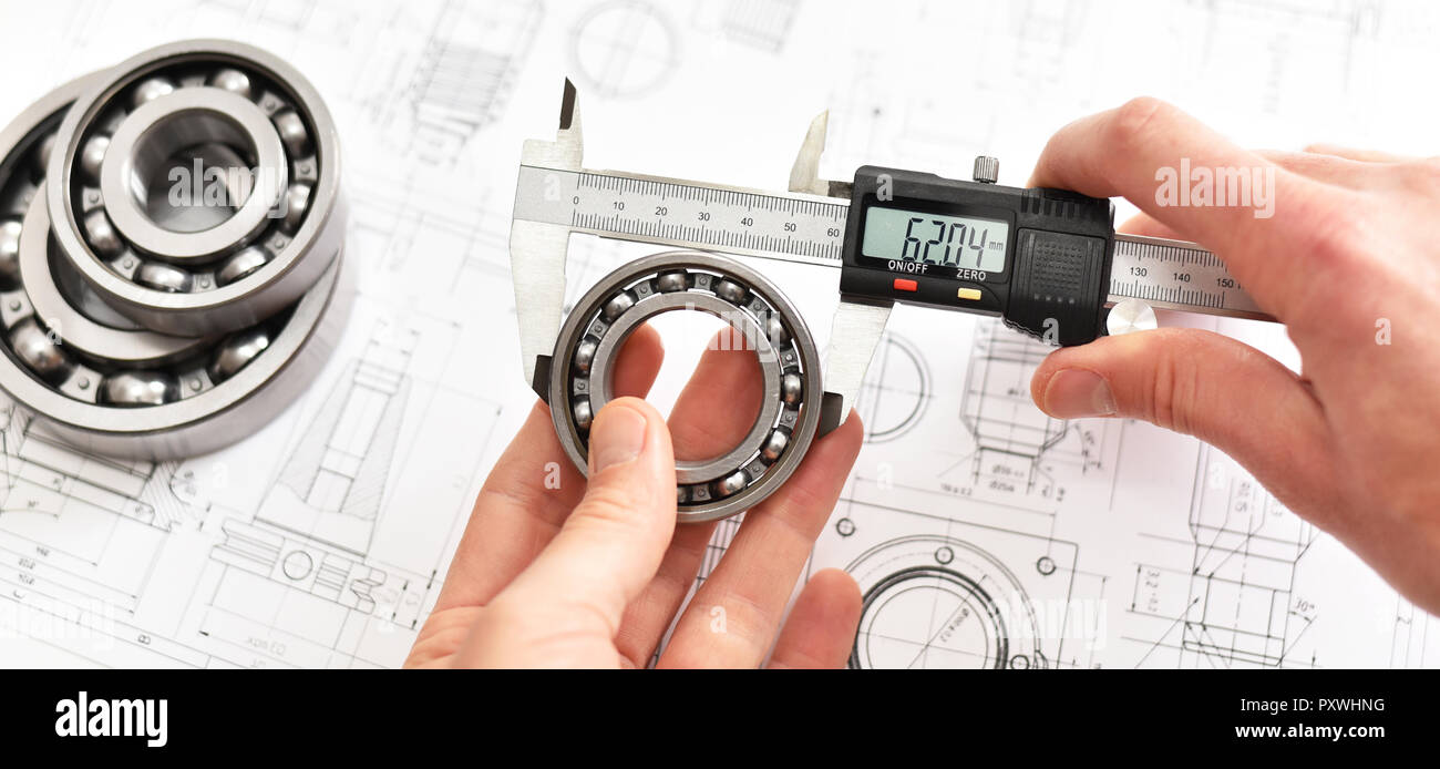 Die Qualitätskontrolle in der modernen Maschinenbau - Bremssattel Messgeräte, technische Zeichnung und Kugellager auf weißem Hintergrund Stockfoto
