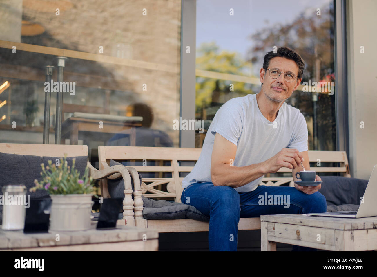 Reifen Geschäftsmann im Café sitzen, Kaffee trinken, mit Laptop Stockfoto