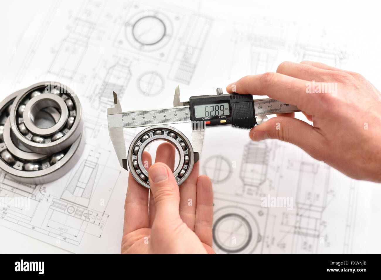 Die Qualitätskontrolle in der modernen Maschinenbau - Bremssattel Messgeräte, technische Zeichnung und Kugellager auf weißem Hintergrund Stockfoto