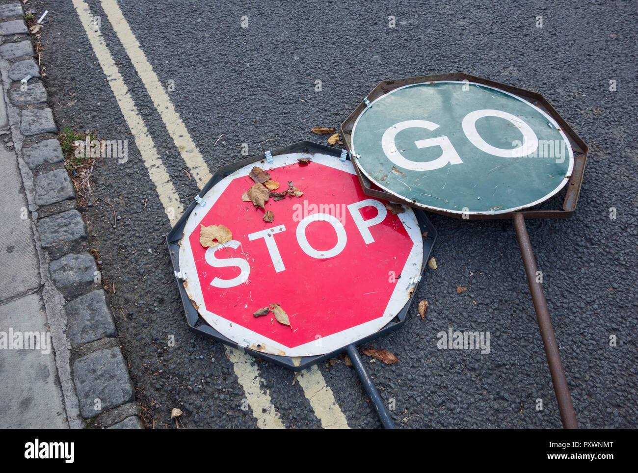 Stop-Go-Verkehrszeichen werden in Großbritannien auf einer Straße weggeworfen Stockfoto