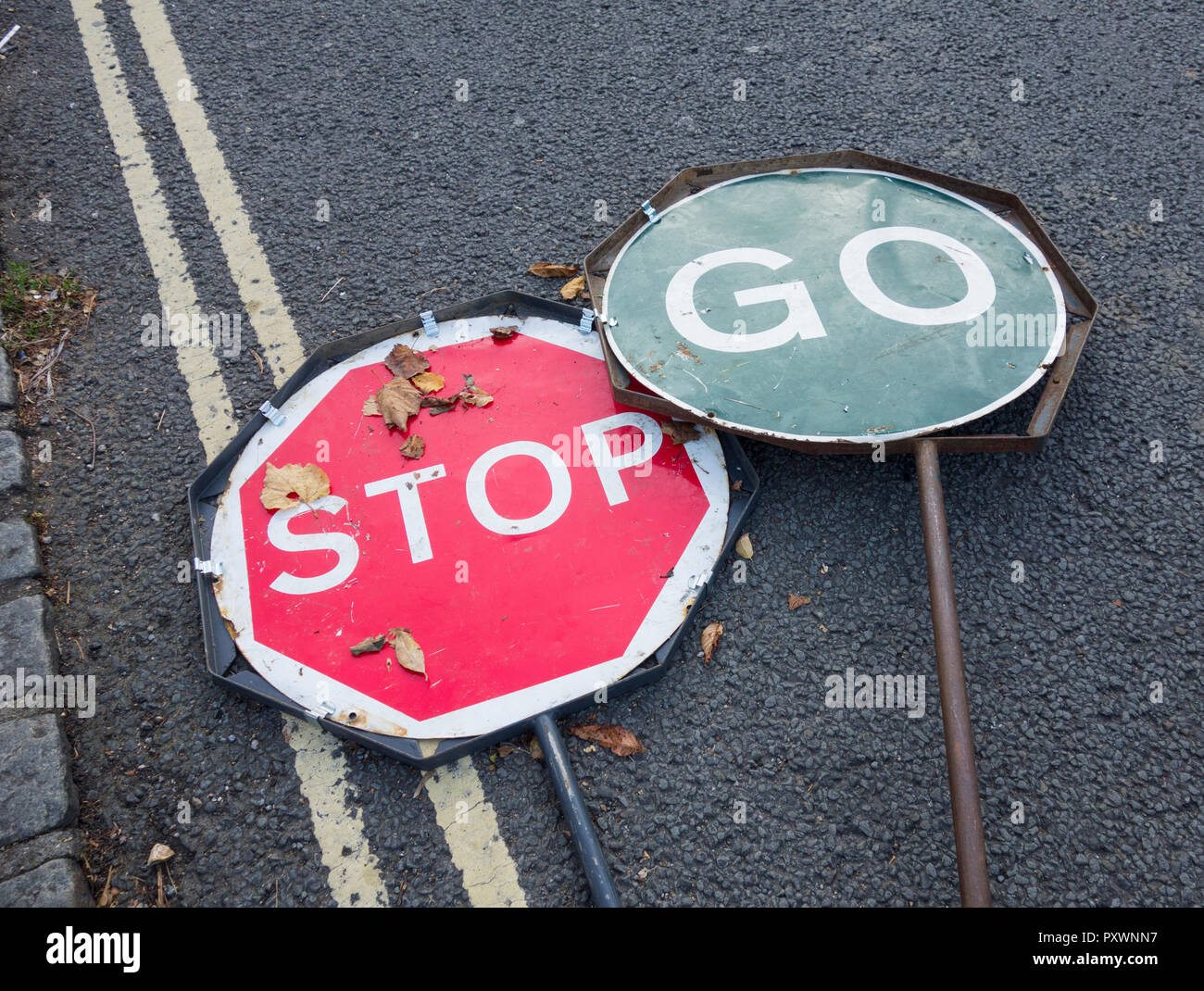 Stop-Go-Verkehrszeichen werden in Großbritannien auf einer Straße weggeworfen Stockfoto